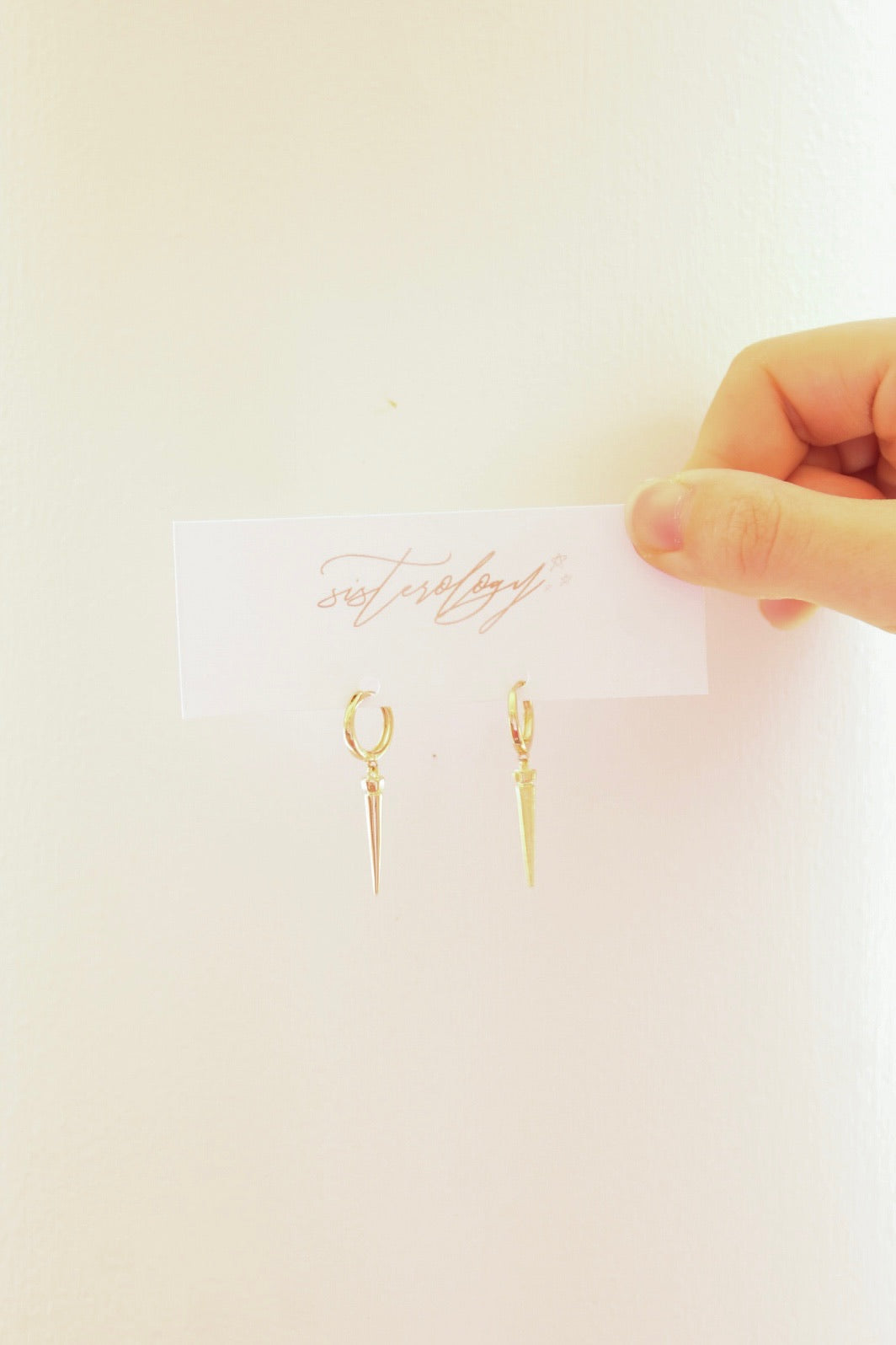 Golden Stella Spike Dangle Huggie Hoops featuring sleek gold-tone metal and a modern spike design.