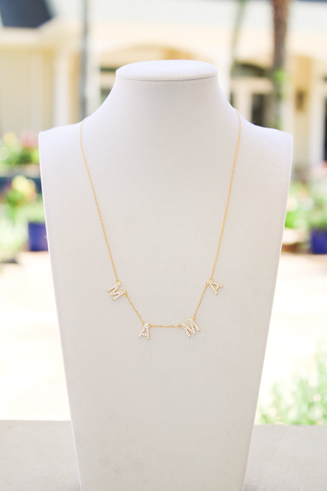 Golden Stella Gold MAMA Necklace featuring a delicate gold pendant with engraved "MAMA" text, stylish jewelry for mothers.