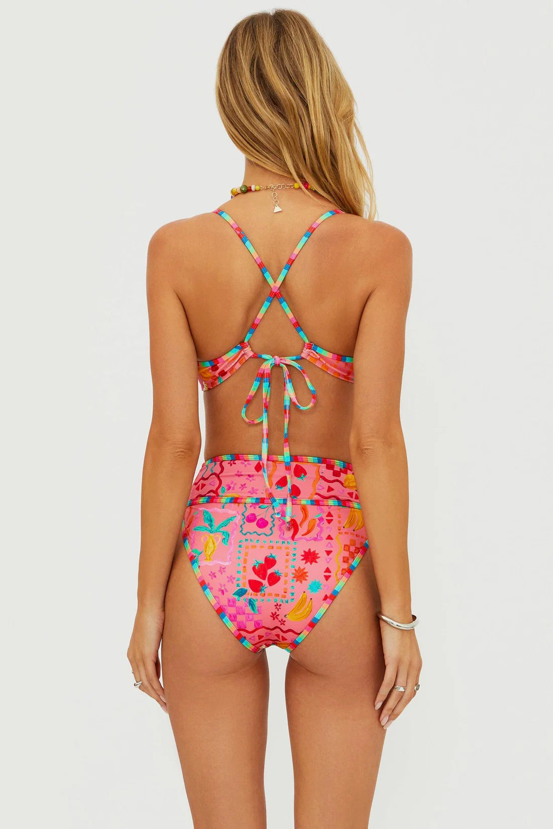 Beach Riot Carlotta Bottom in Passion Fruit with vibrant tropical print, featuring side ties and cheeky coverage.