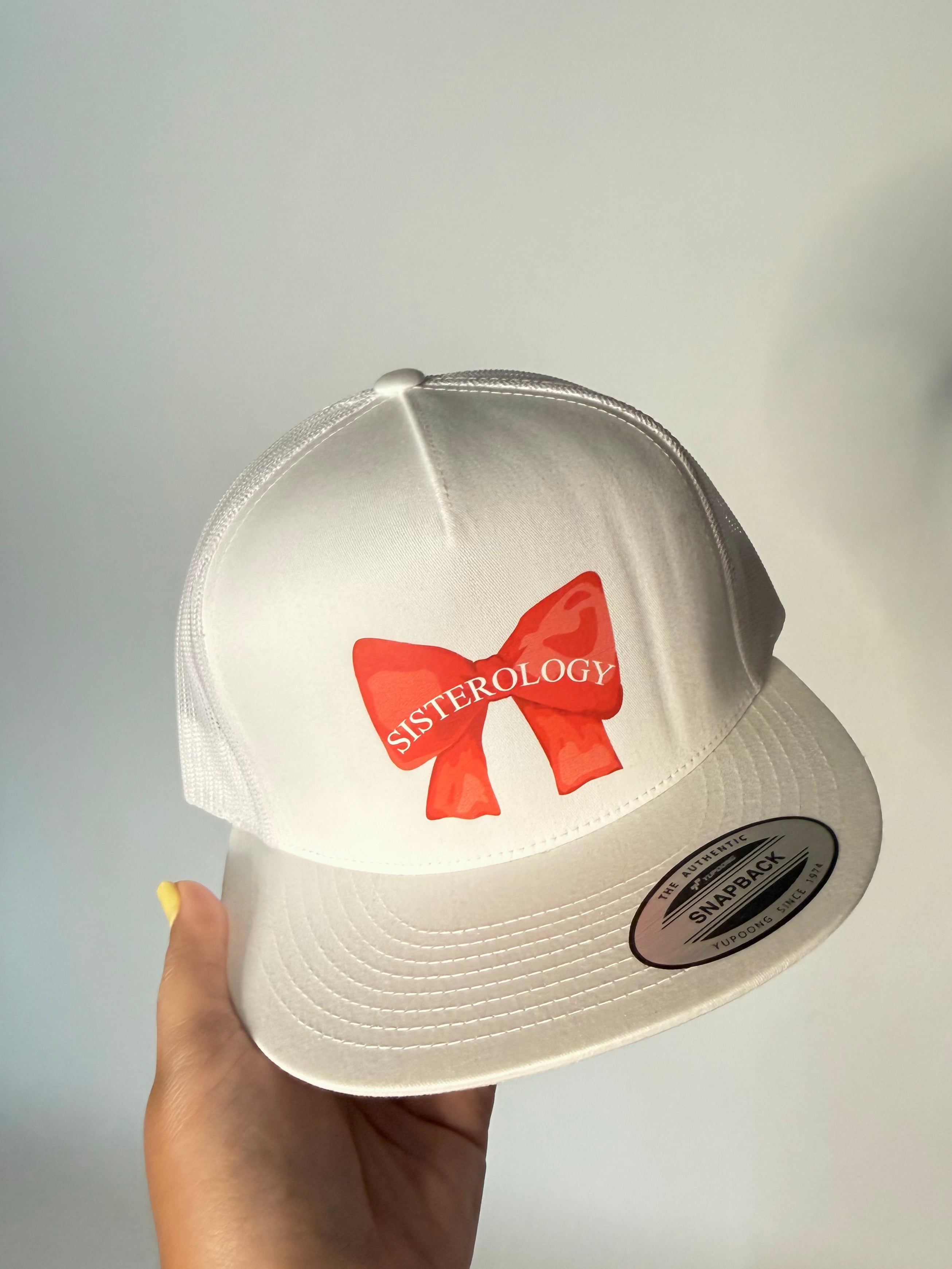 Red Bow Trucker Hat by Shopsisterology featuring a stylish front bow and classic mesh back for casual and trendy wear.