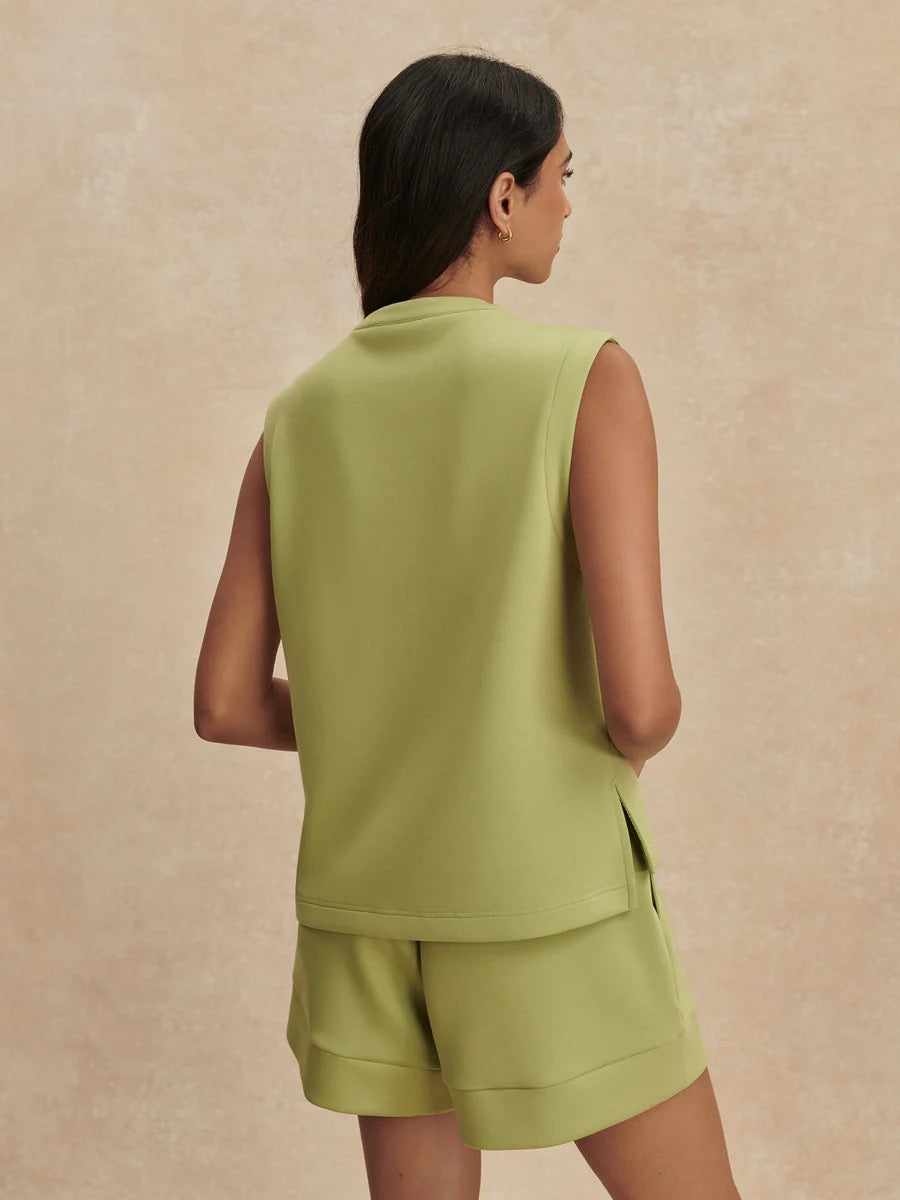 Varley Simmons Half Zip Tank in fern green, showcasing a fitted athletic sleeveless top with a high collar and half zip closure.
