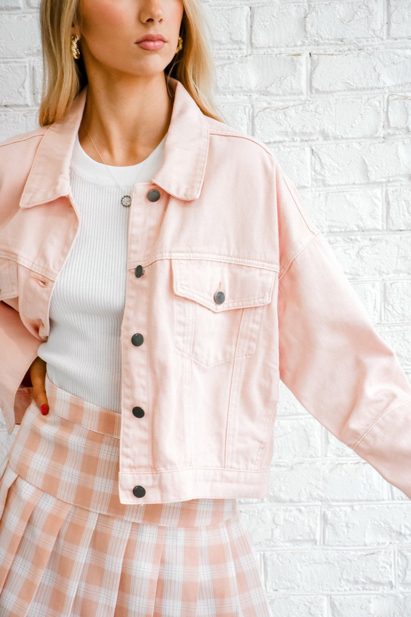 Pink ladies denim jacket by On Twelfth with classic fit and silver button details, displayed on a hanger.