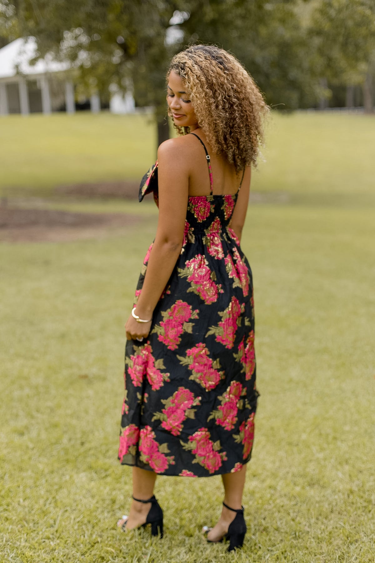 Shopsisterology Poinsettia Midi Dress featuring floral pattern, fitted waist, and elegant midi length on a model.